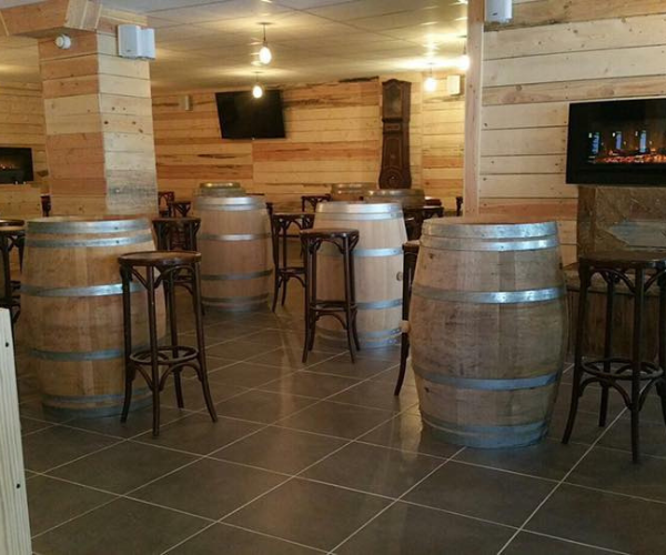 Espace bar de restaurant avec tonneaux en bois en Isère