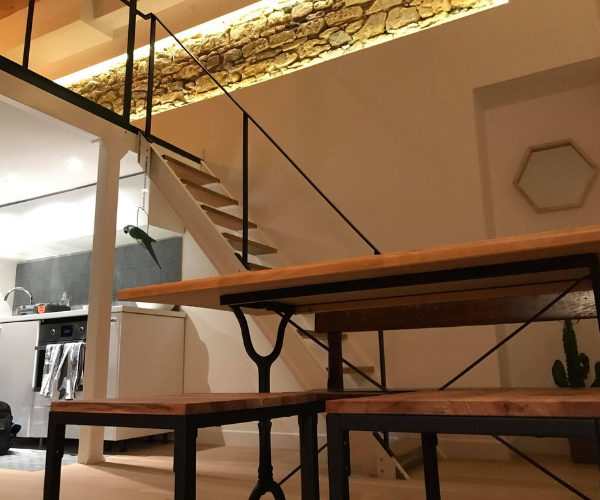 Coin repas aménagé avec escalier et mur en pierre à Lyon
