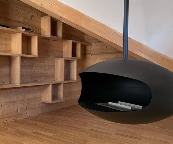 Bibliothèque sur mesure et cheminée suspendue dans un appartement de montagne à Vaujany