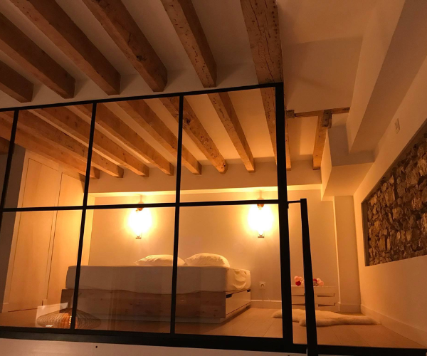 Chambre en mezzanine avec verrière dans un appartement rénové à Lyon
