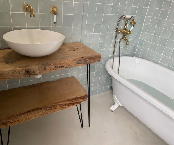 Salle de bain rénovée avec baignoire îlot et meuble en bois massif
